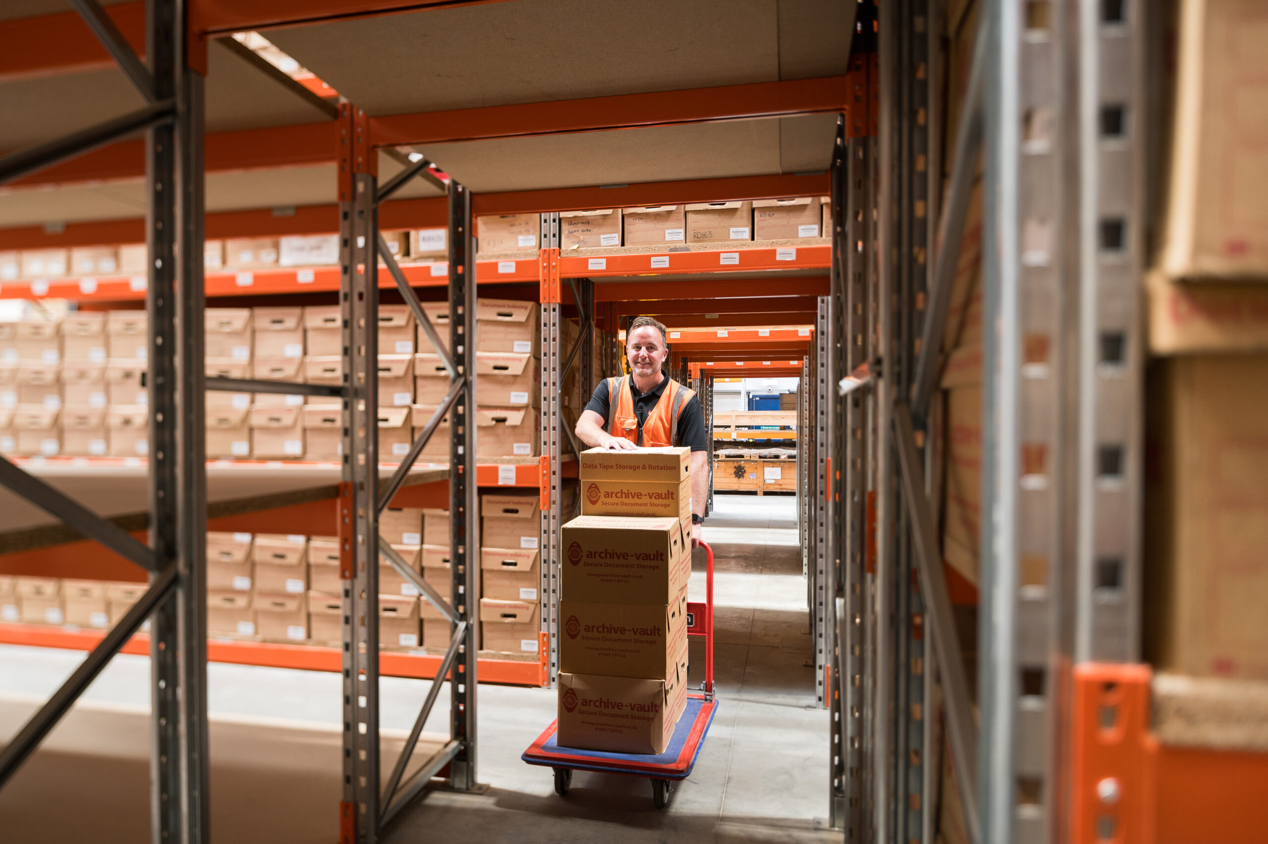 warehouse worker moving boxes full of documents