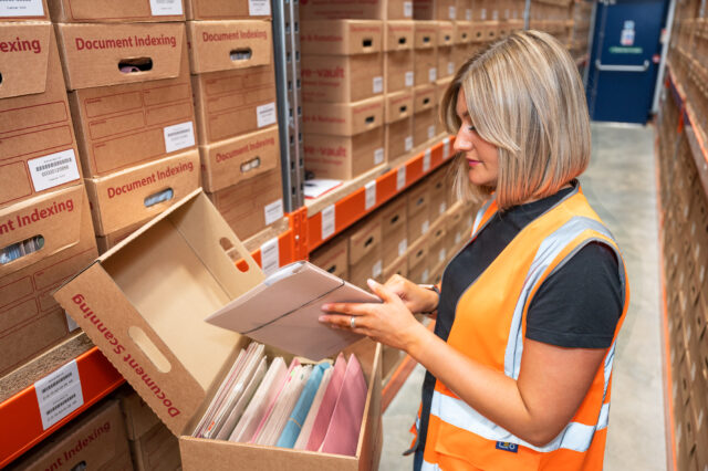 employee locating files in storage box