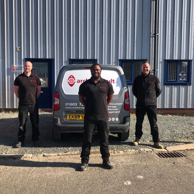 archive vault employees standing in front of van