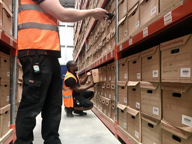 warehouse employees locating document boxes