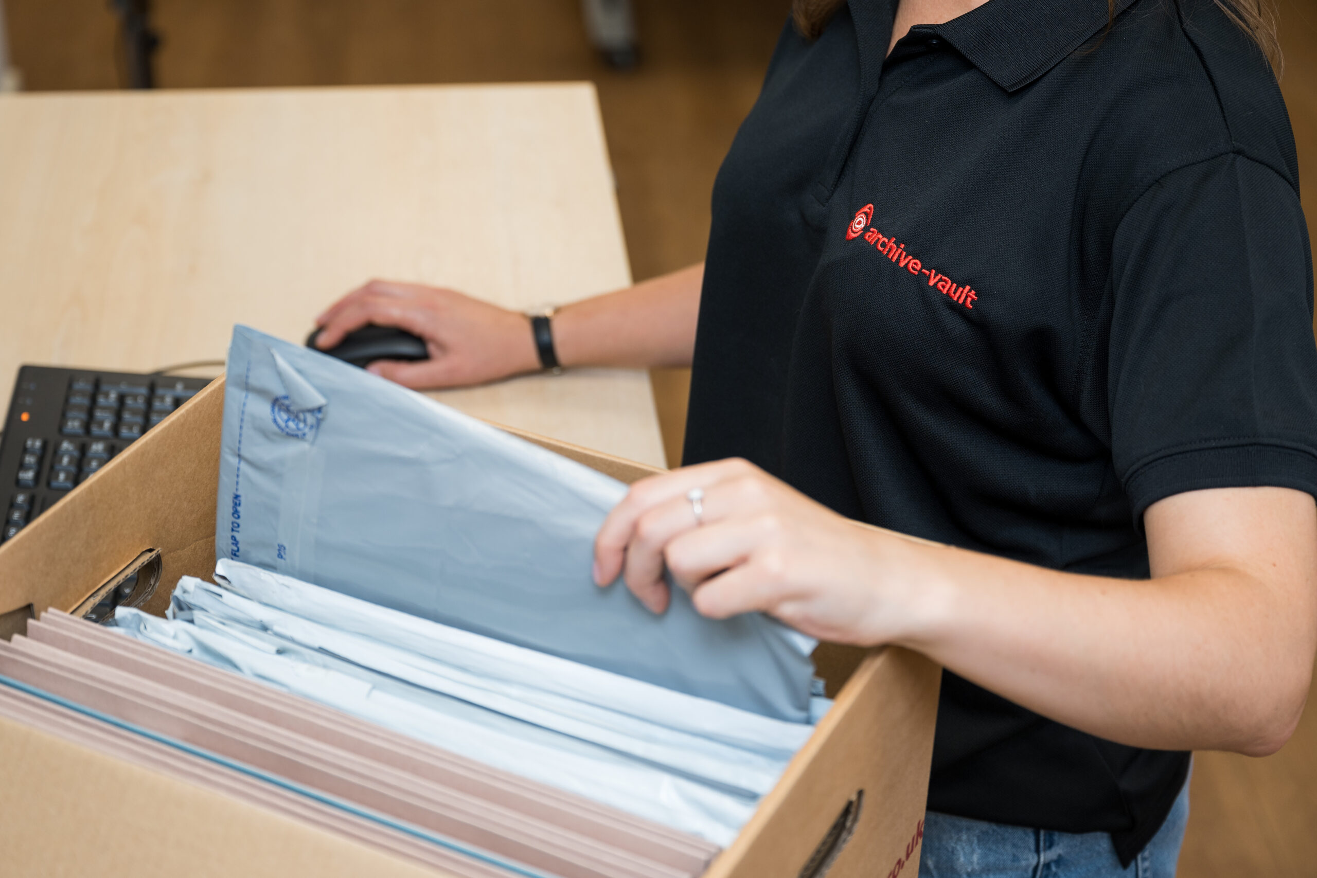 Archive vault employee sorting through documents