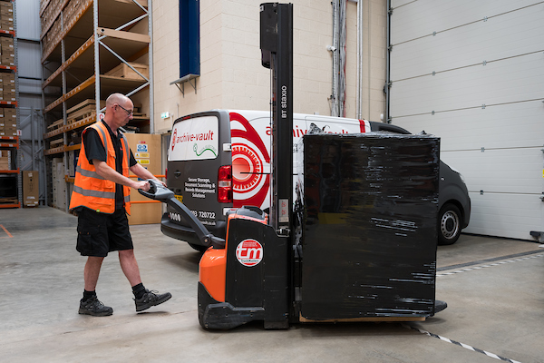 Archive vault staff transporting a parcel of documents